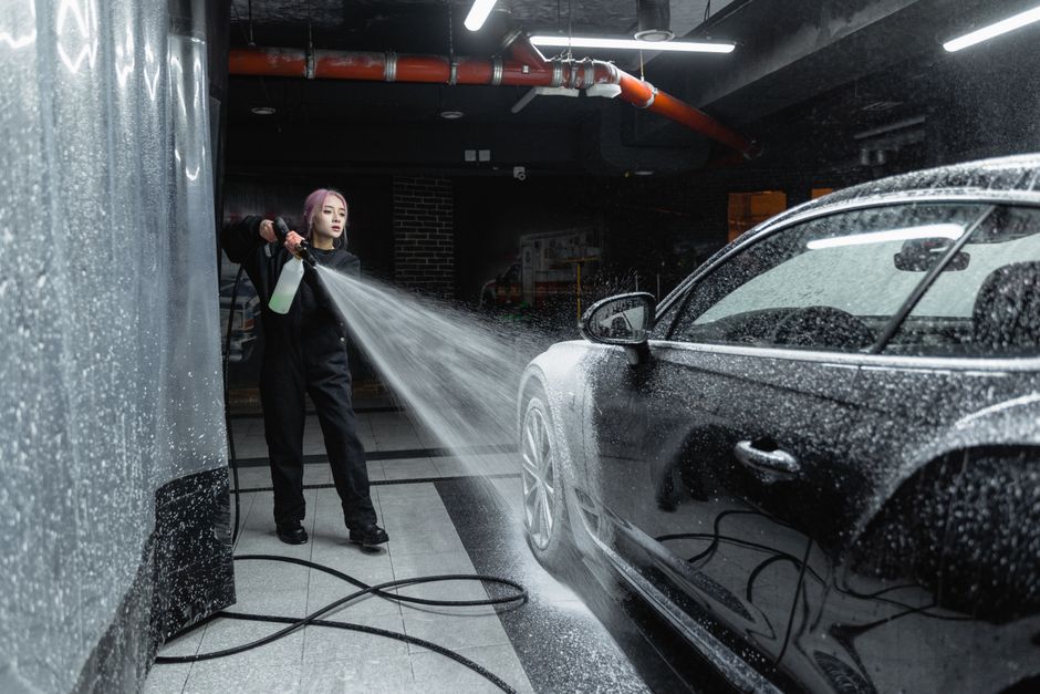 A car covered in thick snow foam during the wash stage of a full detail