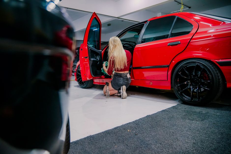 A detailer wiping down and deep cleaning a car's interior trim