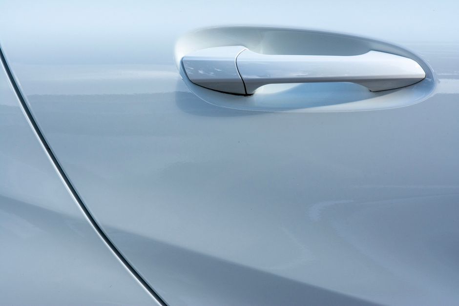 Close-up of glossy, freshly detailed car paint reflecting the studio lights